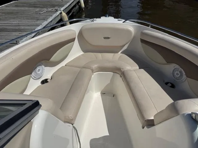 Slide: The Image of 2007 Chaparral 204SSI boat interior with beige seating and speakers near a dock. - 5