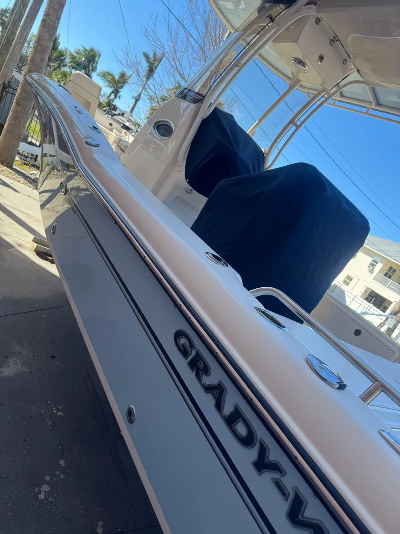 Slide: The Image of 2019 Grady-White 251 Coastal Explorer boat, sleek design, docked under clear blue sky. - 0