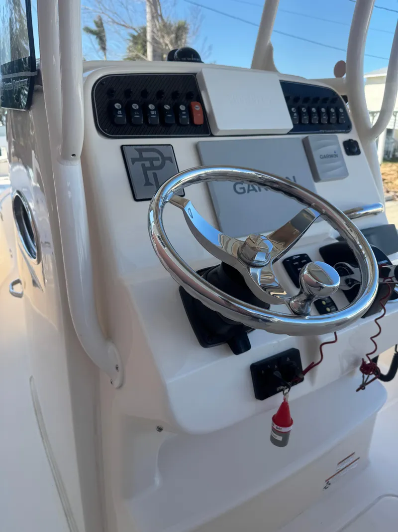 Slide: The Image of 2019 Grady-White 251 Coastal Explorer boat console with steering wheel and controls. - 10