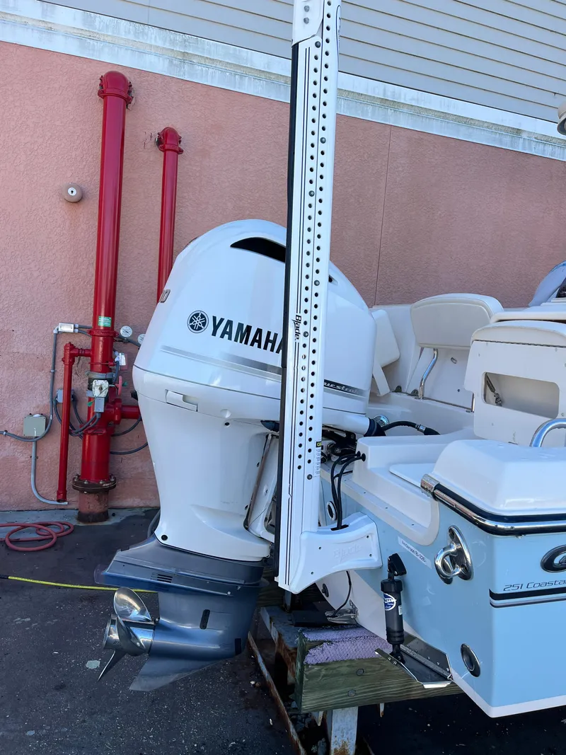 Slide: The Image of 2019 Grady-White 251 Coastal Explorer with Yamaha outboard motor, docked near red pipes. - 2