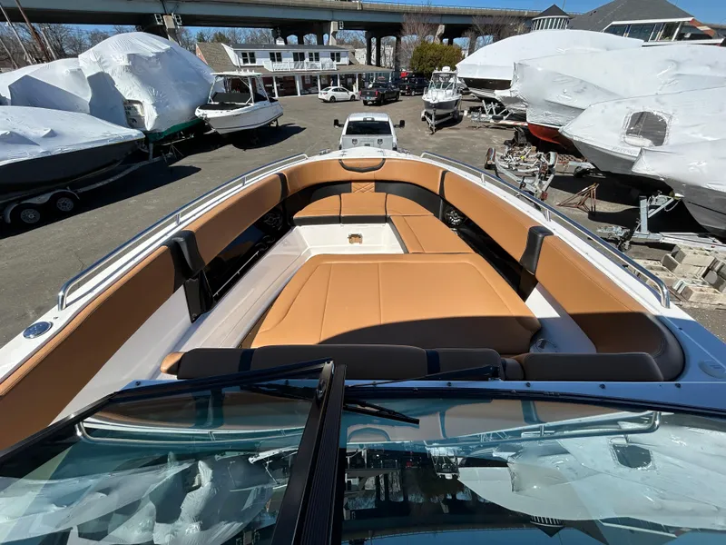 Slide: The Image of 2023 Chaparral 300 OSX boat with tan seating, docked among other boats. - 14