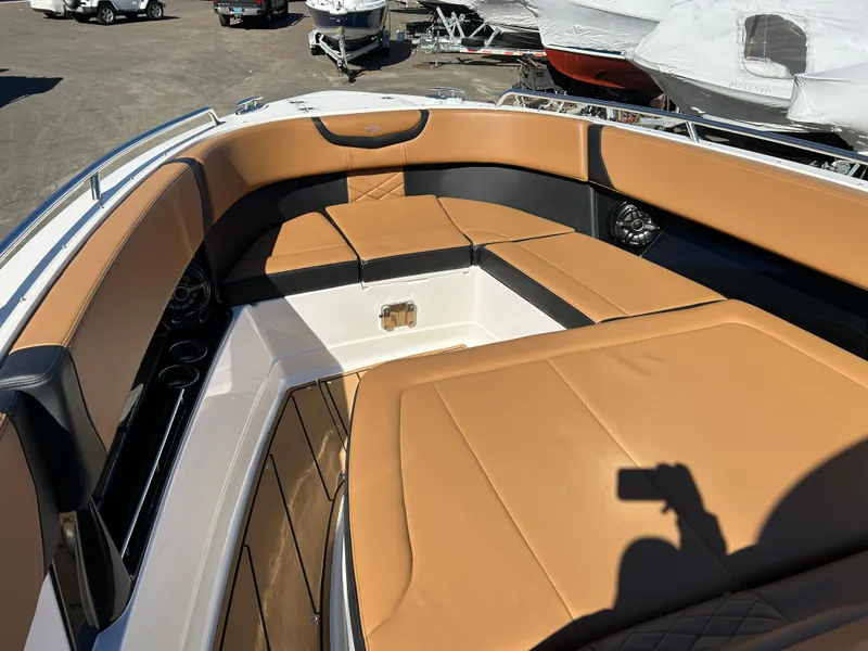 Slide: The Image of 2023 Chaparral 300 OSX boat with tan leather seating in a marina setting. - 15