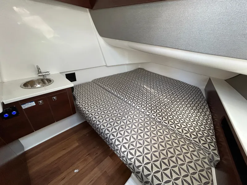 Slide: The Image of 2023 Chaparral 300 OSX cabin interior with bed and sink, featuring modern design. - 17