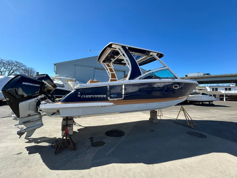 Slide: The Image of 2023 Chaparral 300 OSX boat on display, featuring sleek design and Mercury outboard engines. - 2