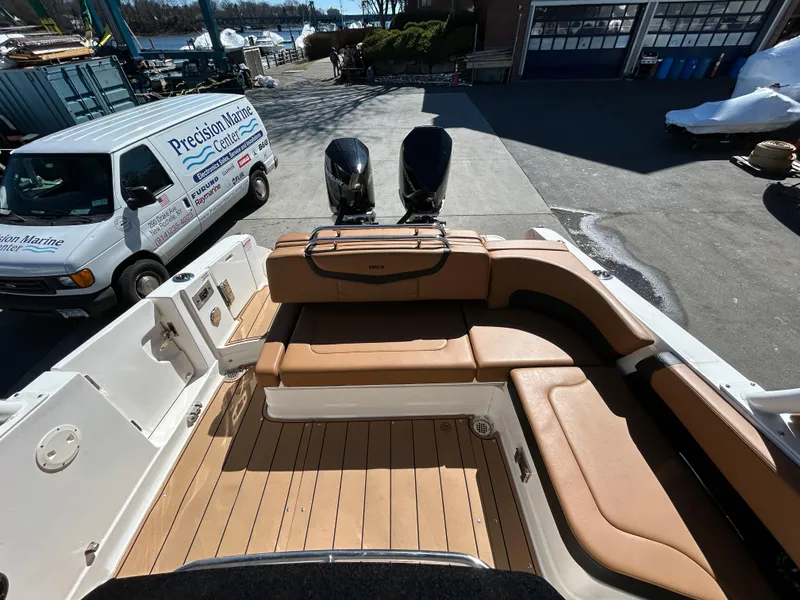 Slide: The Image of 2023 Chaparral 300 OSX boat with tan seating and dual outboard motors. - 5