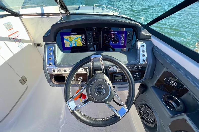 Slide: The Image of 2021 Chaparral 307 SSX boat dashboard with dual Simrad displays and steering wheel. - 19