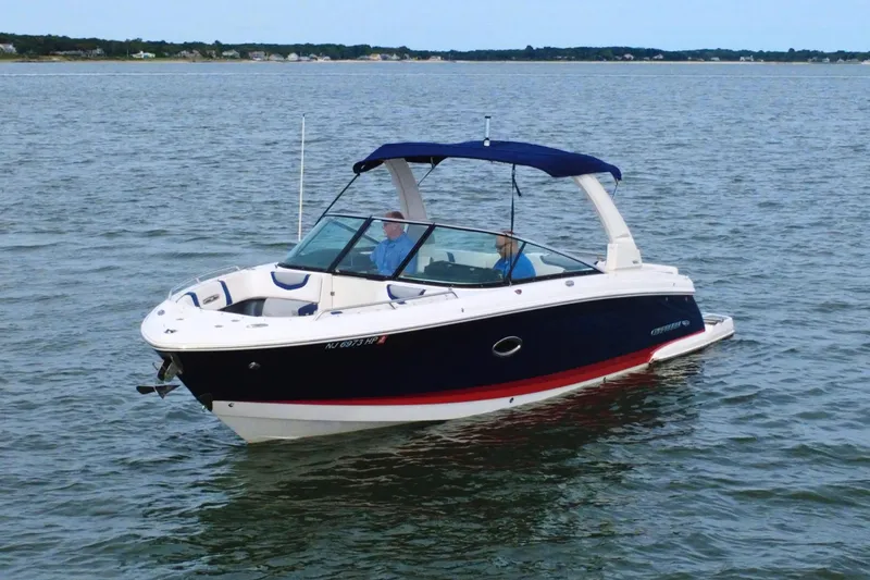 Slide: The Image of 2021 Chaparral 307 SSX boat cruising on a calm lake. - 2