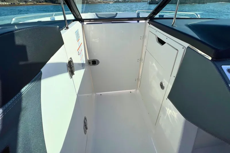Slide: The Image of Interior view of 2021 Chaparral 307 SSX boat, featuring sleek white and navy design. - 21
