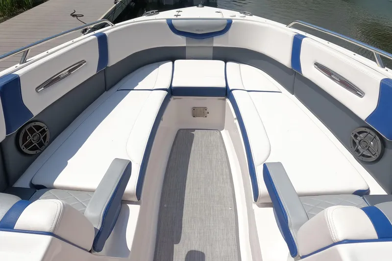 Slide: The Image of 2021 Chaparral 307 SSX boat interior with white and blue seating, dockside view. - 22