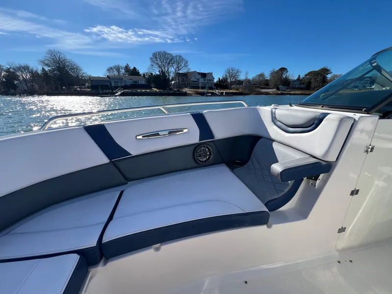 Slide: The Image of 2021 Chaparral 307 SSX boat interior with blue and white seating by the water. - 24