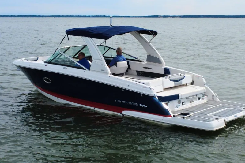Slide: The Image of 2021 Chaparral 307 SSX boat cruising on a calm lake. - 3
