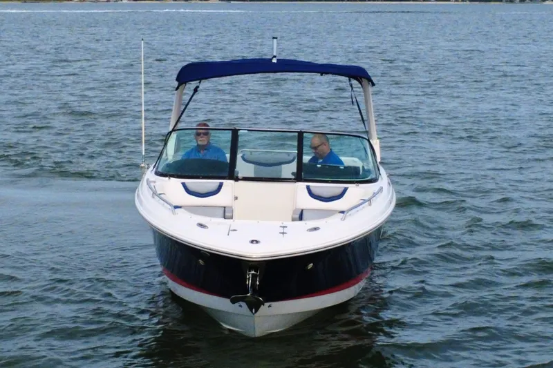 Slide: The Image of 2021 Chaparral 307 SSX boat cruising on open water with two passengers. - 6