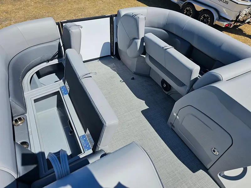 Slide: The Image of 2025 Bentley Pontoons LEGACY 243 QUAD SWINGBACK interior with gray seating and storage compartments. - 22