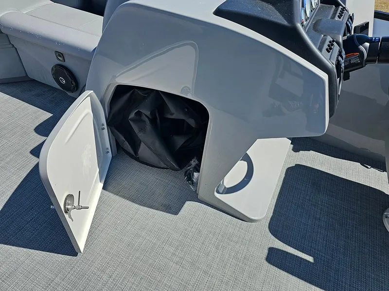 Slide: The Image of 2025 Bentley Pontoons LEGACY 243 QUAD SWINGBACK helm storage compartment with open door. - 24