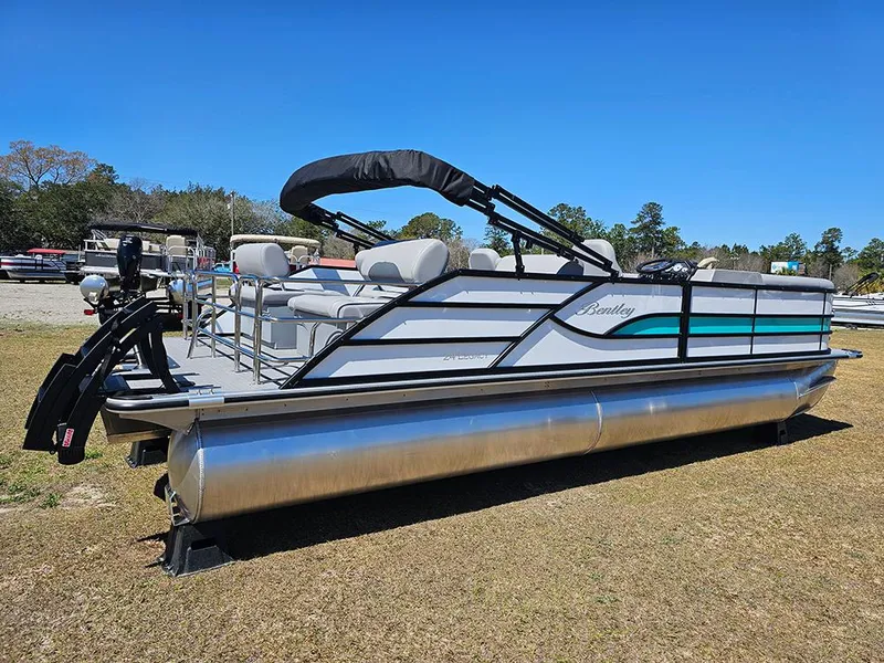 Slide: The Image of 2025 Bentley Pontoons LEGACY 243 QUAD SWINGBACK on grass, showcasing sleek design and seating. - 3