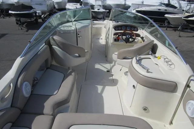 Slide: The Image of 2004 Sea Ray 270 Sundeck interior with seating and helm, docked among other boats. - 20