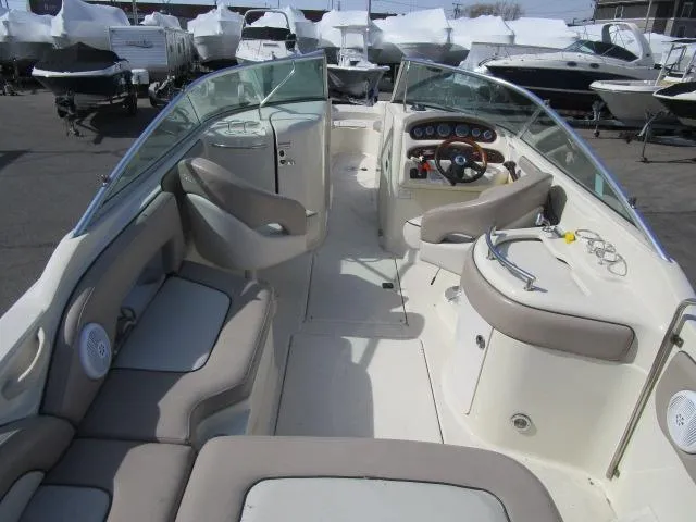 Slide: The Image of 2004 Sea Ray 270 Sundeck interior with seating and helm, docked among other boats. - 4