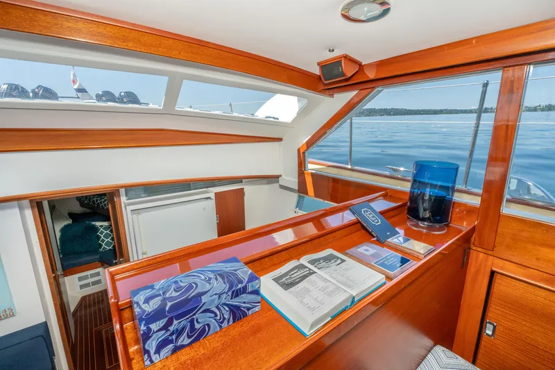 Slide: The Image of 1965 Chris-Craft 57 Constellation interior with wood finish, open book, and scenic water view. - 27