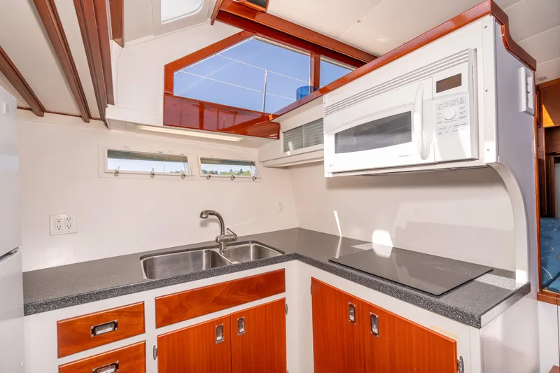 Slide: The Image of 1965 Chris-Craft 57 Constellation kitchen with modern appliances and wooden cabinetry. - 30