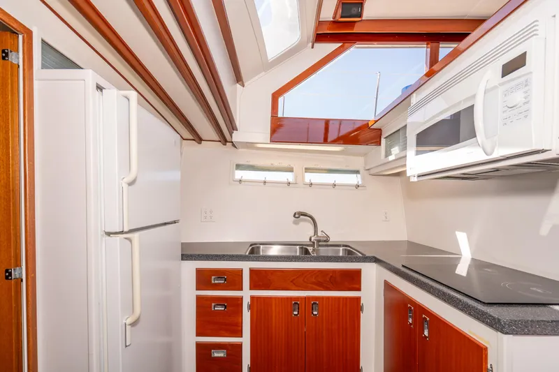 Slide: The Image of 1965 Chris-Craft 57 Constellation kitchen with wood cabinets, sink, and modern appliances. - 31