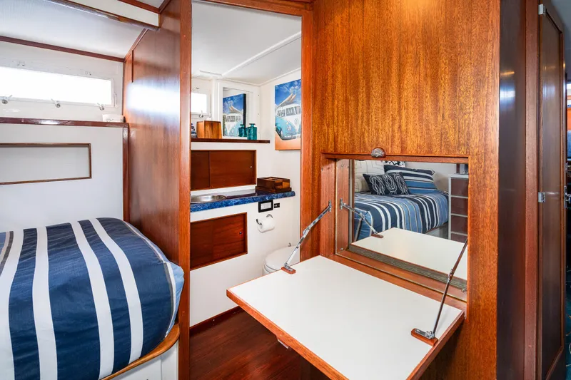 Slide: The Image of 1965 Chris-Craft 57 Constellation interior with wood paneling and striped bedding. - 39