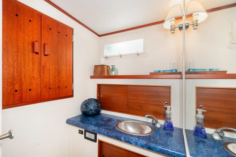 Slide: The Image of Luxurious 1965 Chris-Craft 57 Constellation bathroom with wooden cabinets and blue countertop. - 44