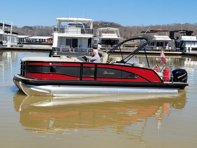 Slide: The Image of 2022 Barletta L23UC pontoon boat on calm water, docked at a marina. - 27