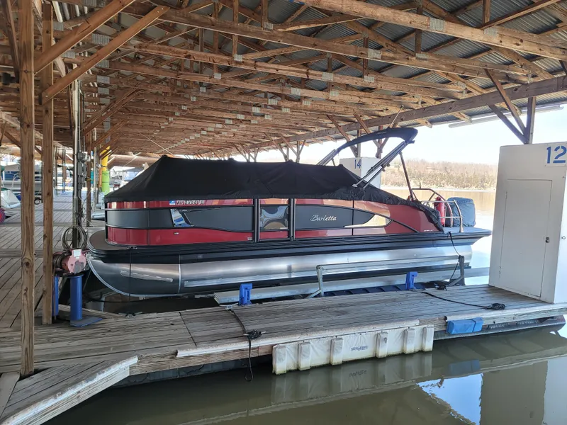 Slide: The Image of 2022 Barletta L23UC pontoon boat docked under wooden shelter. - 29
