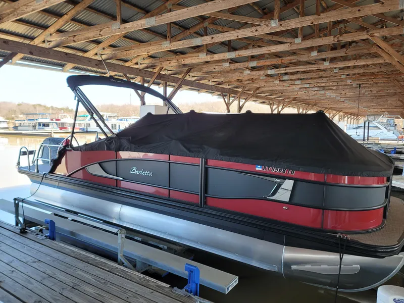 Slide: The Image of 2022 Barletta L23UC pontoon boat docked under a wooden shelter. - 31