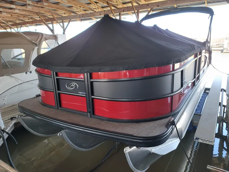 Slide: The Image of 2022 Barletta L23UC pontoon boat with black cover docked in a marina. - 34