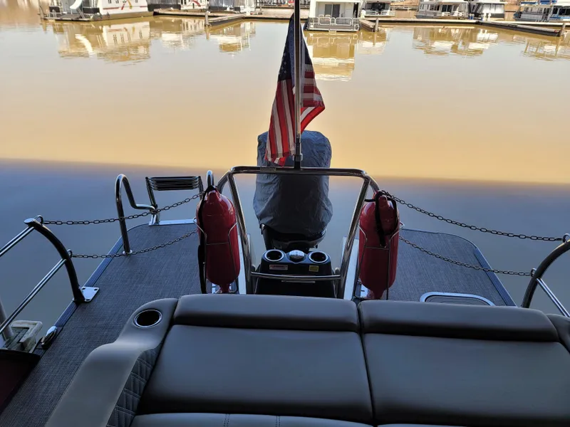 Slide: The Image of 2022 Barletta L23UC pontoon boat with American flag on calm water. - 36