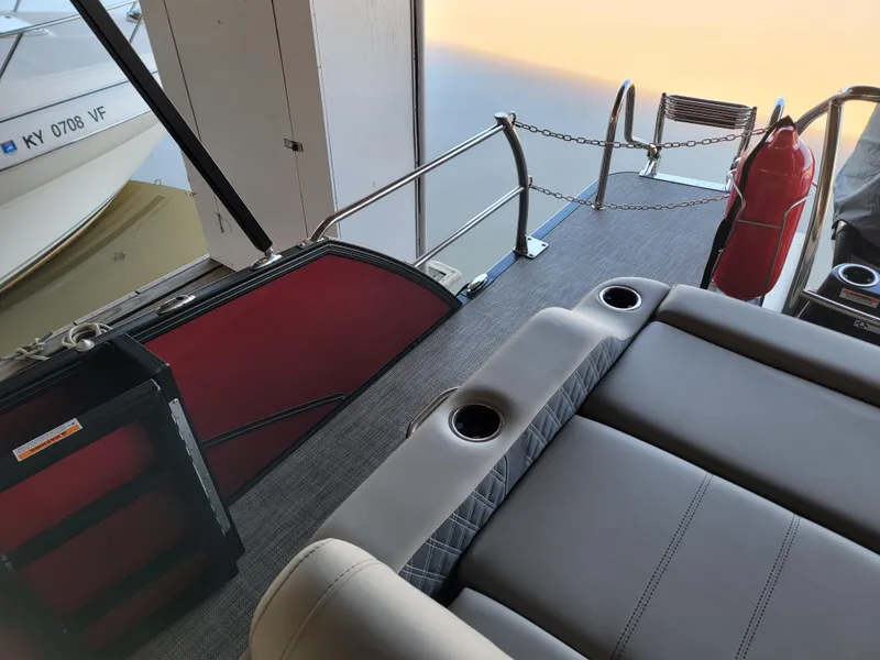 Slide: The Image of 2022 Barletta L23UC boat interior with gray seating and cup holders, docked near water. - 37