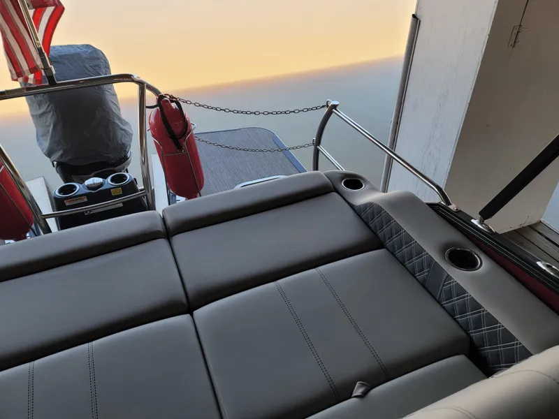 Slide: The Image of 2022 Barletta L23UC boat interior with luxurious seating and cup holders at sunset. - 38