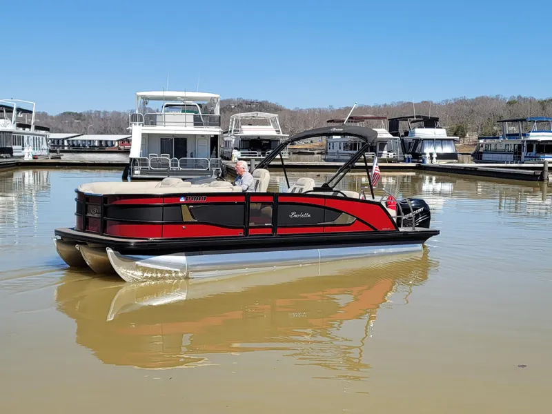 Slide: The Image of 2022 Barletta L23UC pontoon boat in a marina, featuring sleek red and black design. - 46