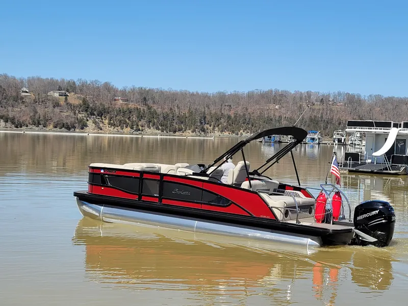 Slide: The Image of 2022 Barletta L23UC pontoon boat on a calm lake with scenic background. - 50