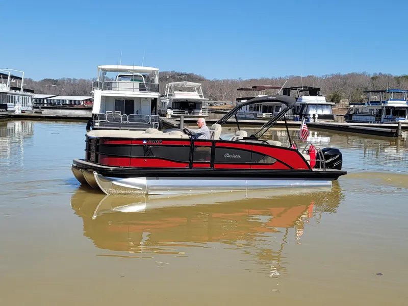Slide: The Image of 2022 Barletta L23UC pontoon boat on a calm lake near a marina. - 51
