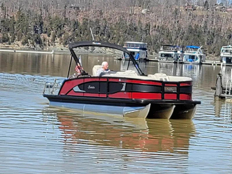 Slide: The Image of 2022 Barletta L23UC pontoon boat on a calm lake with scenic background. - 53