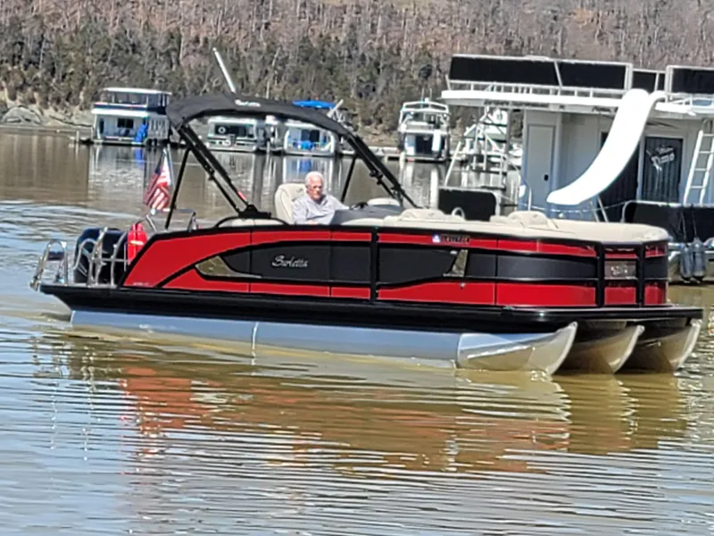 Slide: The Image of 2022 Barletta L23UC pontoon boat on a lake with houseboats in the background. - 54