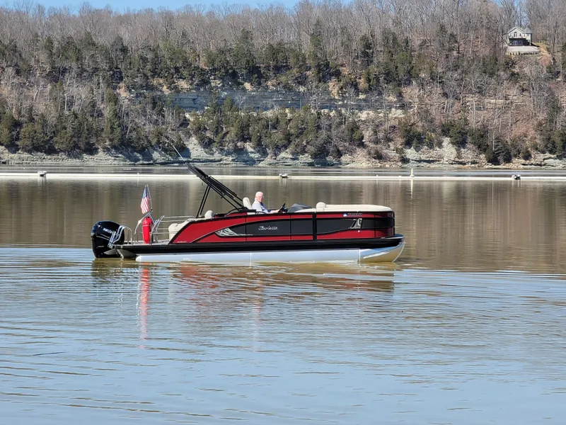 Slide: The Image of 2022 Barletta L23UC pontoon boat on a calm lake with wooded shoreline. - 55