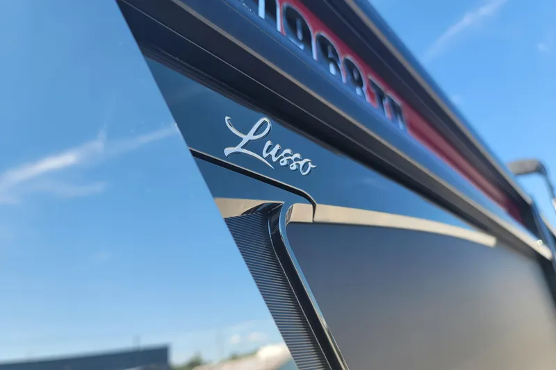 Slide: The Image of 2022 Barletta L23UC boat with "Lusso" emblem, sleek design under clear blue sky. - 7