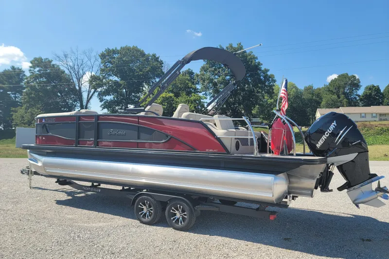 Slide: The Image of 2022 Barletta L23UC pontoon boat with Mercury engine on a trailer, parked outdoors. - 9