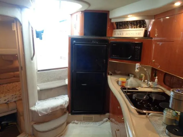 Slide: The Image of Interior of 1999 Sea Ray 400 Sundancer yacht with kitchen and cozy cabin area. - 14