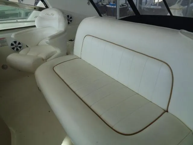 Slide: The Image of 1999 Sea Ray 400 Sundancer interior with white leather seating and helm chair. - 17