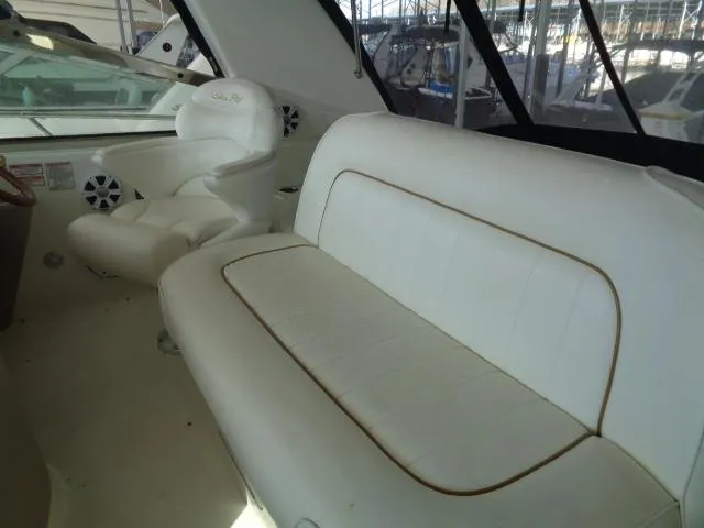 Slide: The Image of 1999 Sea Ray 400 Sundancer interior with white seating and helm chair. - 22