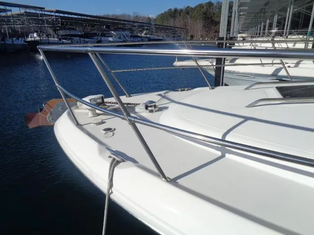 Slide: The Image of 1999 Sea Ray 400 Sundancer yacht docked at marina, featuring sleek white deck and railing. - 26
