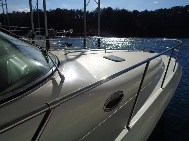 Slide: The Image of 1999 Sea Ray 400 Sundancer yacht on water, reflecting sunlight, with sleek design and railing. - 31