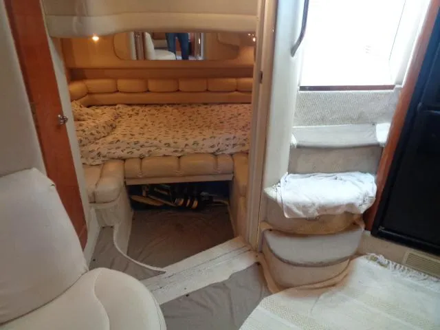 Slide: The Image of 1999 Sea Ray 400 Sundancer interior cabin with bed and stairs, featuring cozy seating. - 4
