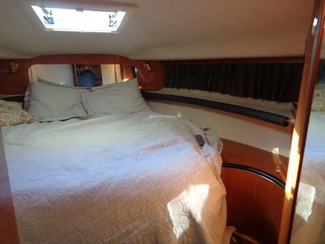 Slide: The Image of 1999 Sea Ray 400 Sundancer cabin with cozy bed and natural light. - 8