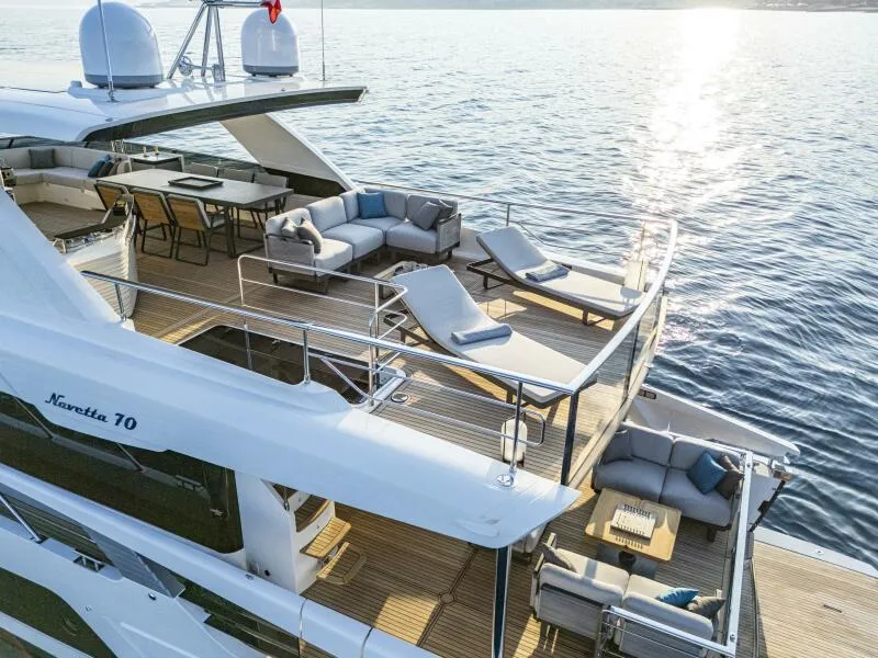 Slide: The Image of Luxurious 2025 Absolute 70 Navetta yacht with spacious deck and elegant seating on the water. - 27