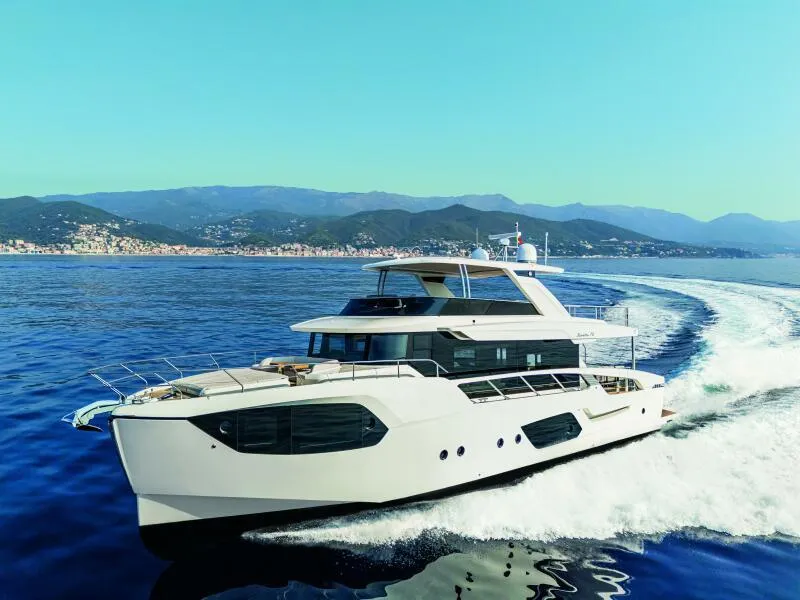 Slide: The Image of 2025 Absolute 70 Navetta yacht cruising on open sea with scenic mountain backdrop. - 30